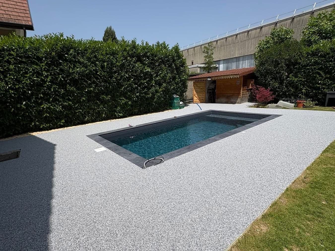 Piscine 6×3 m terminée avec liner armé gris anthracite, margelles foncées et plage minérale claire