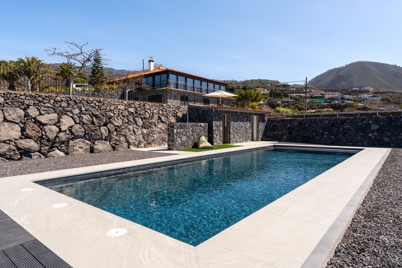 Bassin contemporain en Alkorplan Touch Elegance bordé de murs en pierre volcanique