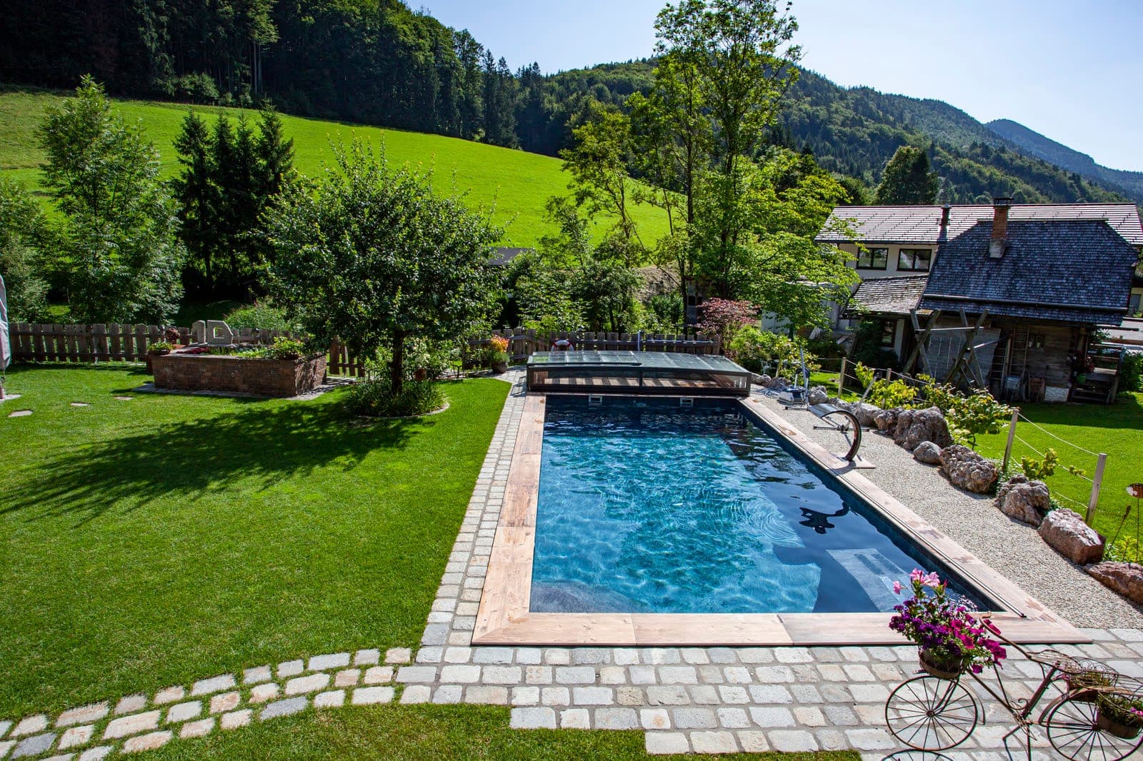 Piscine en membrane Alkorplan Touch Elegance, ardoise noire, dans un jardin pavé